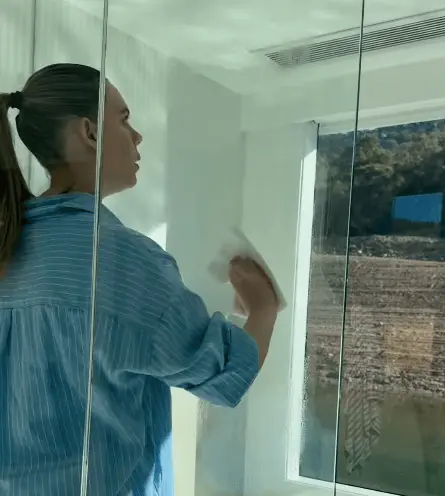 Customer applying EnduroShield to shower glass — DIY at home