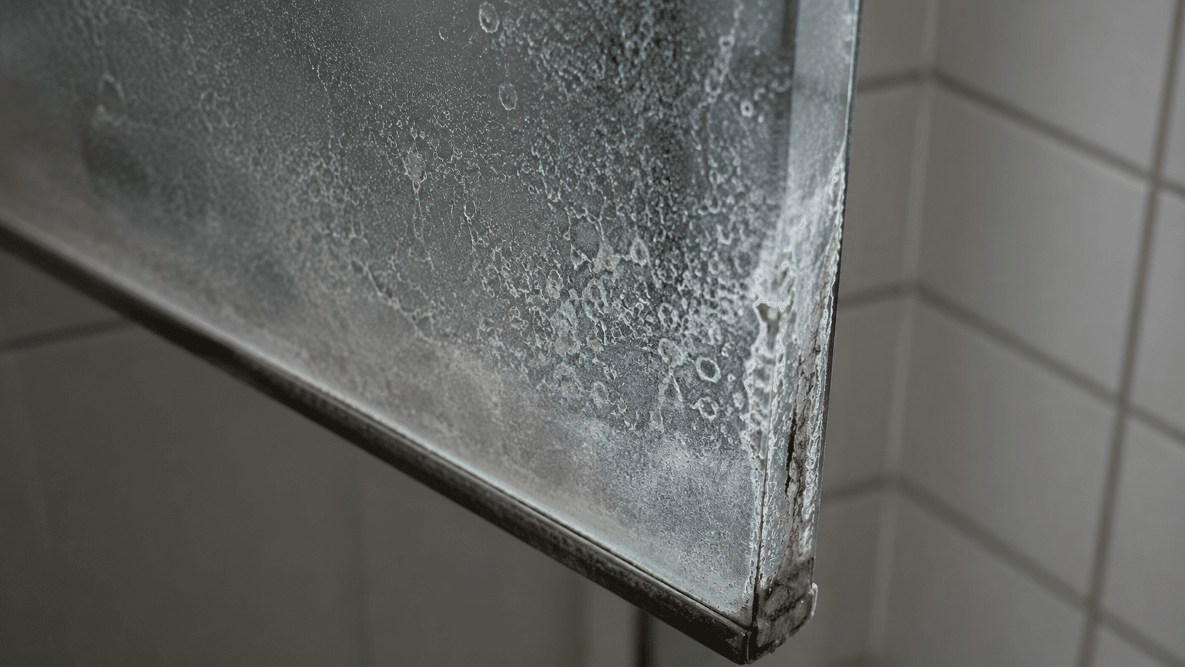 Shower glass corner permanently etched by hard water