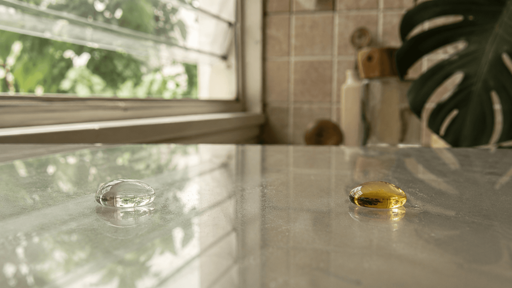 Side-by-side comparison: water droplet and oil droplet both beading off treated shower glass, hydrophobic and oleophobic